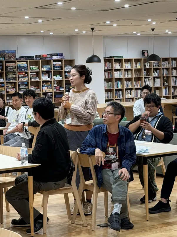 会場の中でマイクを手にふりかえりを語る参加者と、耳を傾ける人たち
